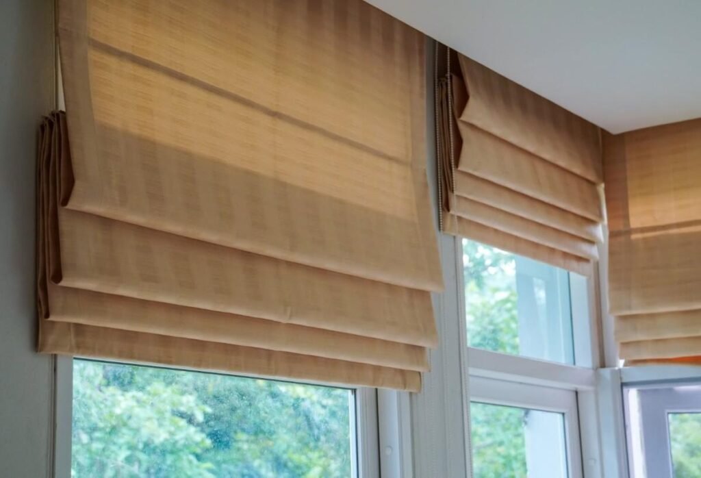 Roman-blinds-beige fabric-folding-into horizontal-pleats-when-raised